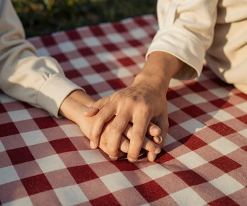 Clasped hands on a picnic blanket - small penis fetish and preference matching